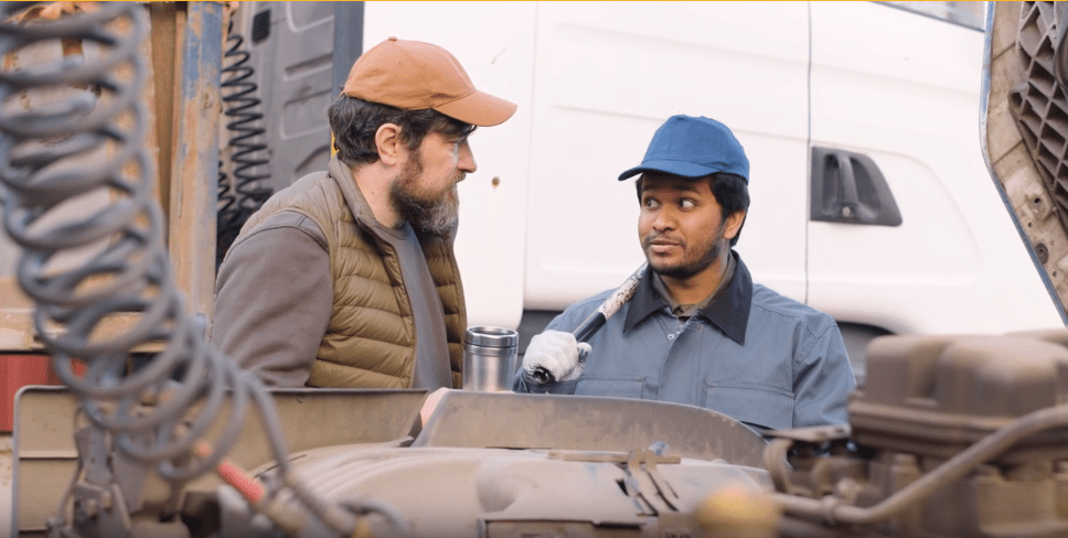 Abella Energy technicians inspecting a truck engine